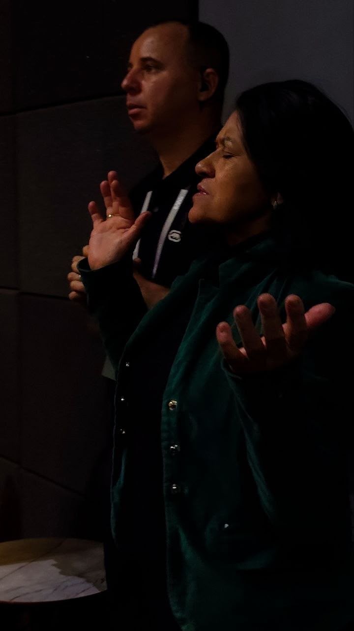 Membros da igreja em oração com as mãos levantadas