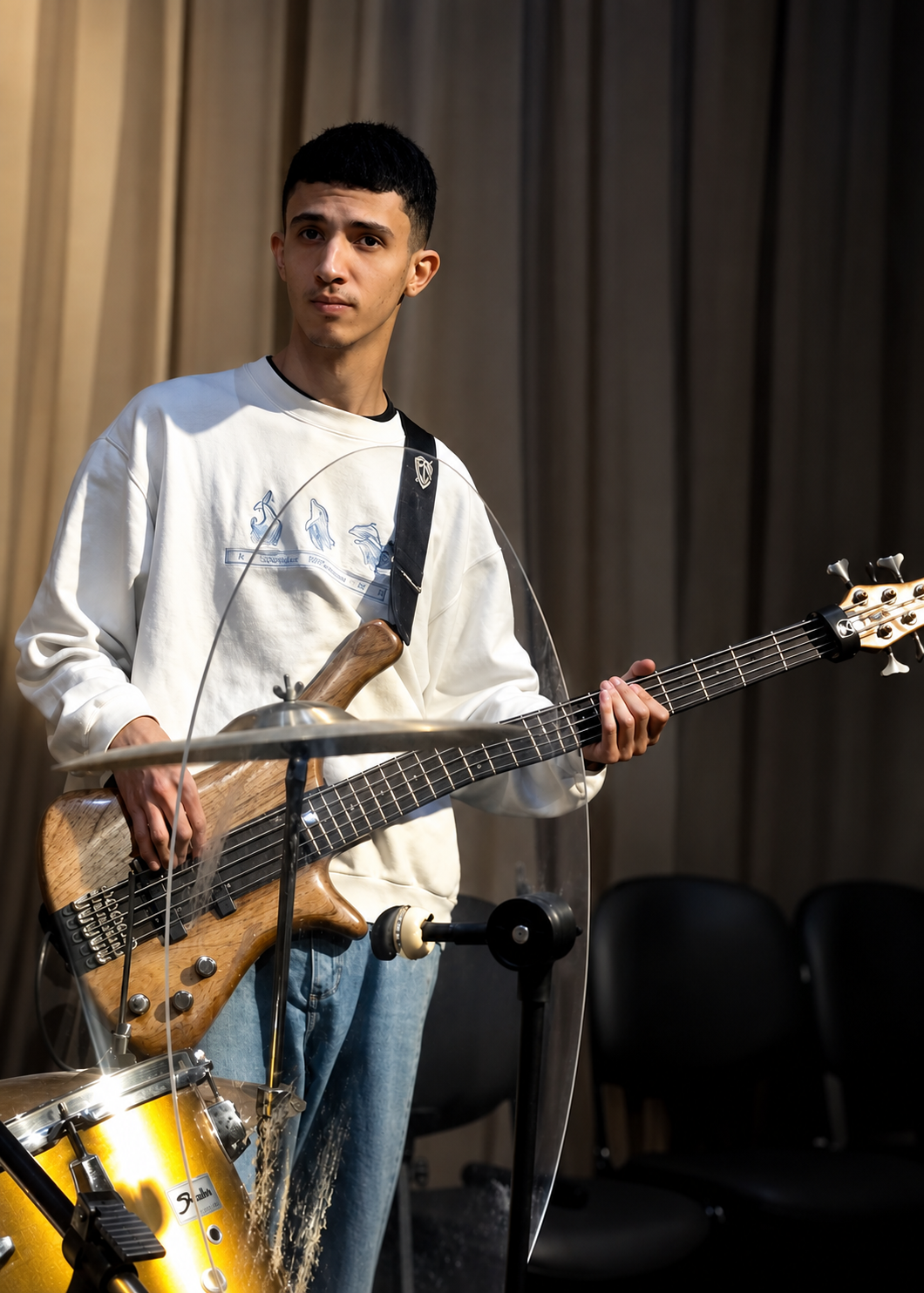 Jovem da IMAC tocando baixo durante o louvor